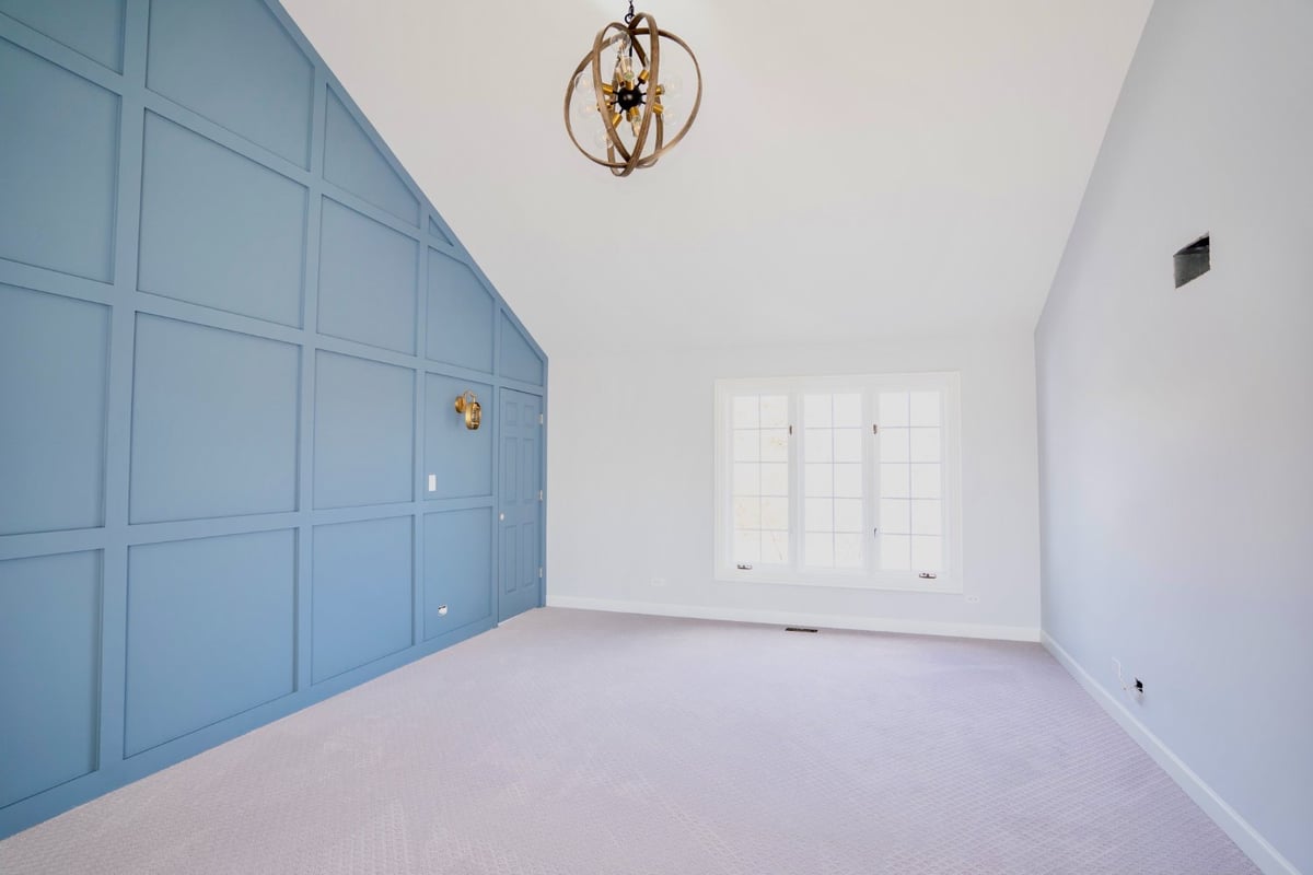remodeled bedroom featuring floor-to-ceiling blue panel molding and bright natural light by Skor Construction in Barrington, IL -optimized