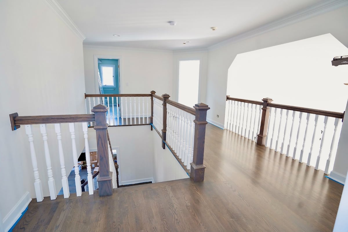 second-floor landing with hardwood flooring and custom staircase railings in a whole house remodel by Skor Construction in Barri-optimized