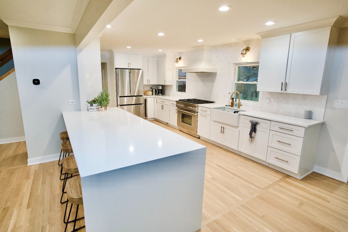 spacious kitchen remodel with oversized waterfall island, white shaker cabinets, and premium finishes by Skor Construction in Mo-optimized