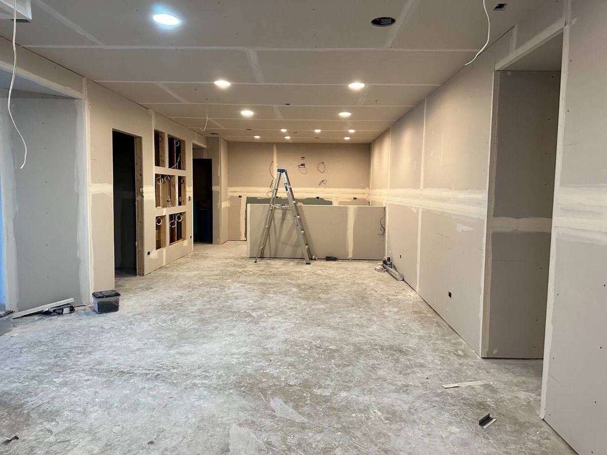 basement renovation under construction with finished drywall, electrical rough-ins, and open floor plan by Skor Construction in -optimized
