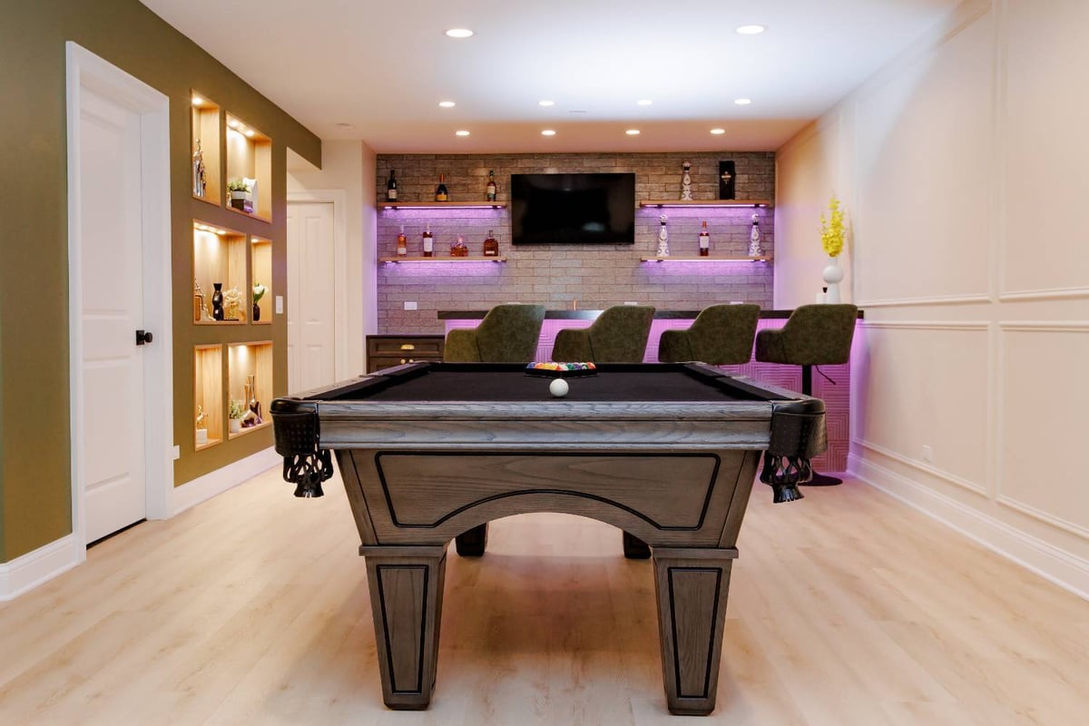 entertainment-focused basement renovation featuring billiards, bar seating, and stone accent wall by Skor Construction in Palati-optimized