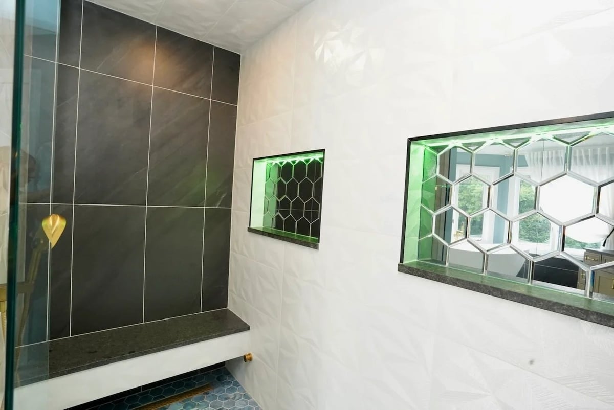 bathroom remodeling shower niche detail in barrington il featuring green led lit hexagonal tile niches dark stone bench and textured white wall tiles by skor construction