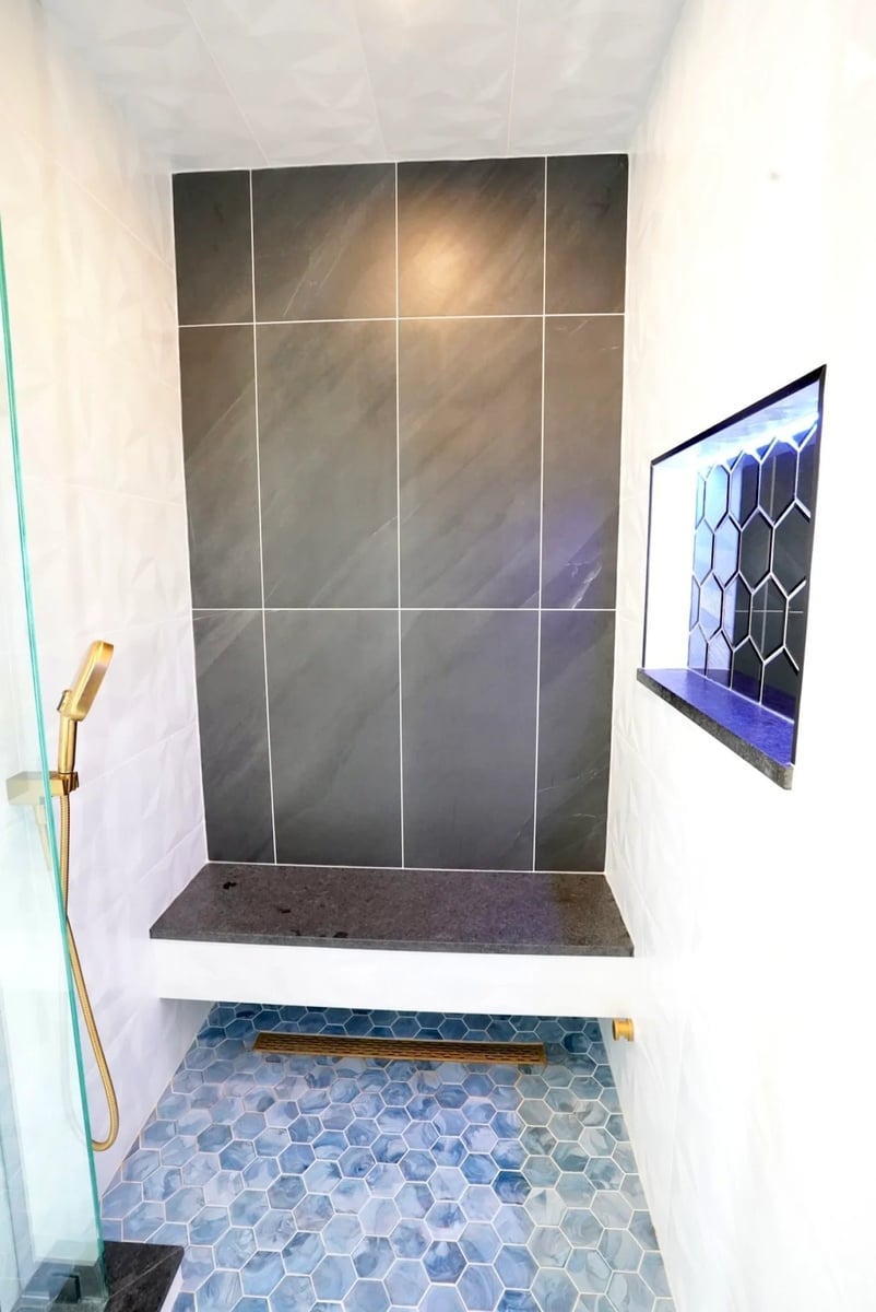 custom shower remodeling in barrington il with dark tile accent wall built in bench blue hexagon floor tiles and gold handheld fixture by skor construction