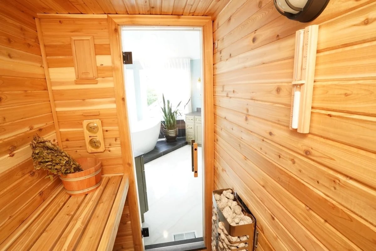 interior cedar sauna remodeling in barrington il with glass door view into master bathroom stone heater thermometer and wood benches by skor construction