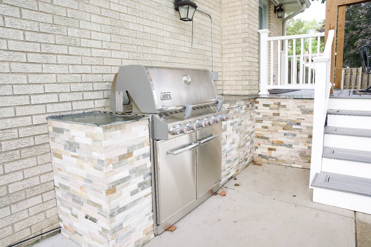 outdoor kitchen and grilling station by Skor Construction in Mount Prospect, IL featuring stone veneer cabinetry and stainless s-optimized