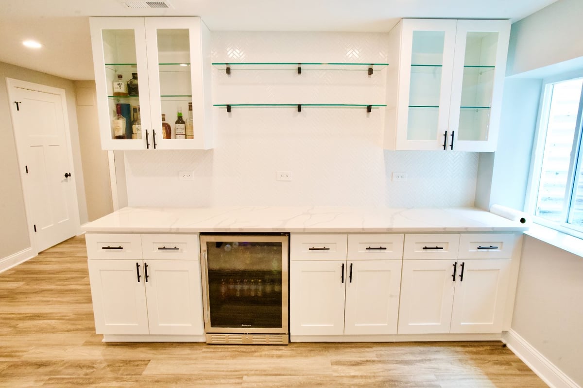 finished basement bar by Skor Construction in Hoffman Estates, IL featuring white shaker cabinets, beverage cooler, and tile bac-optimized