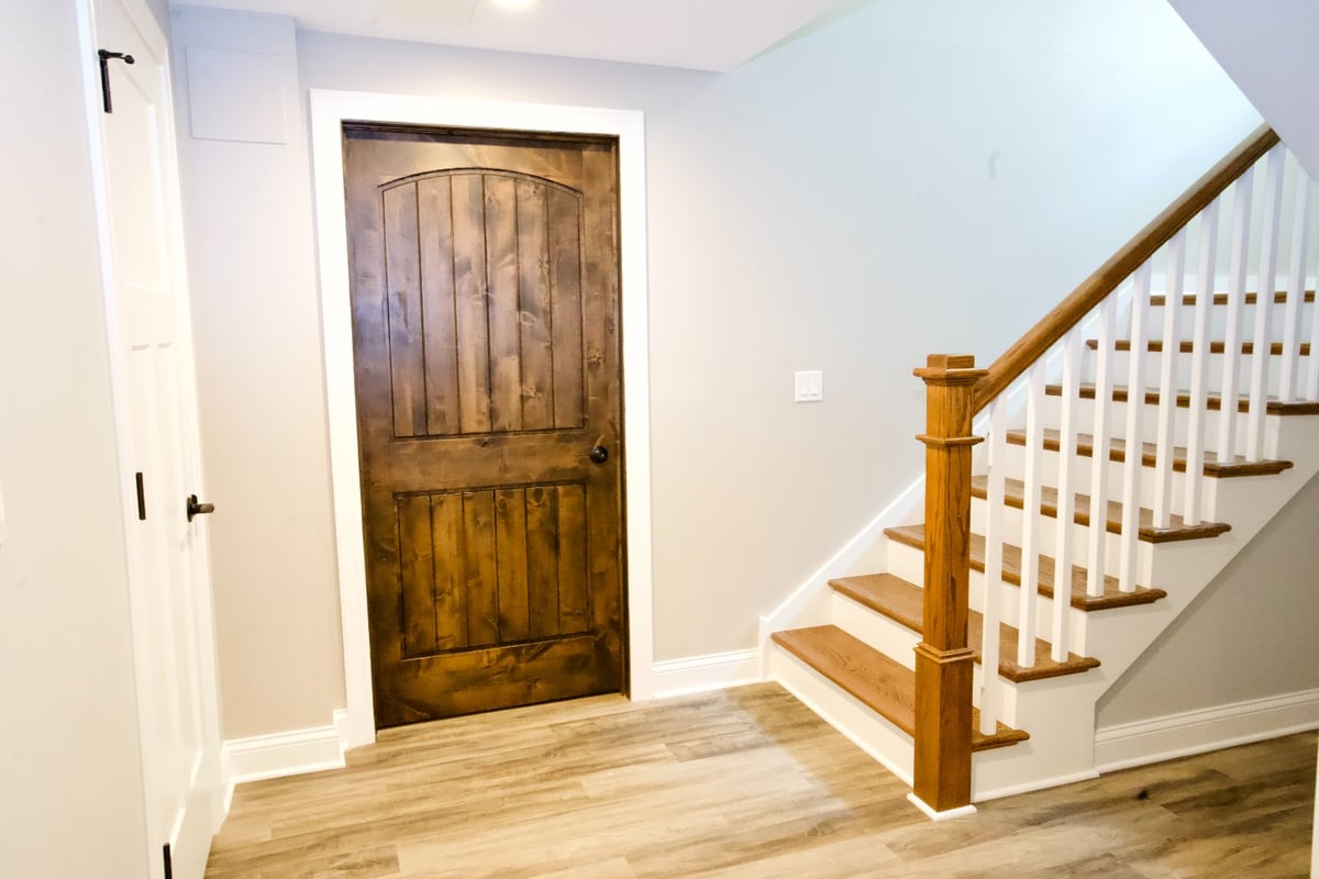 finished basement entryway by Skor Construction in Hoffman Estates, IL showcasing upgraded stairs and custom interior trim detai-optimized
