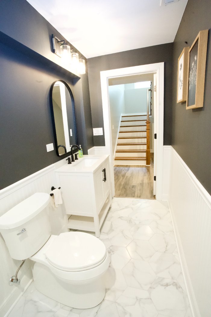 modern basement bathroom remodel by Skor Construction in Hoffman Estates, IL featuring a custom vanity, black fixtures, and tile