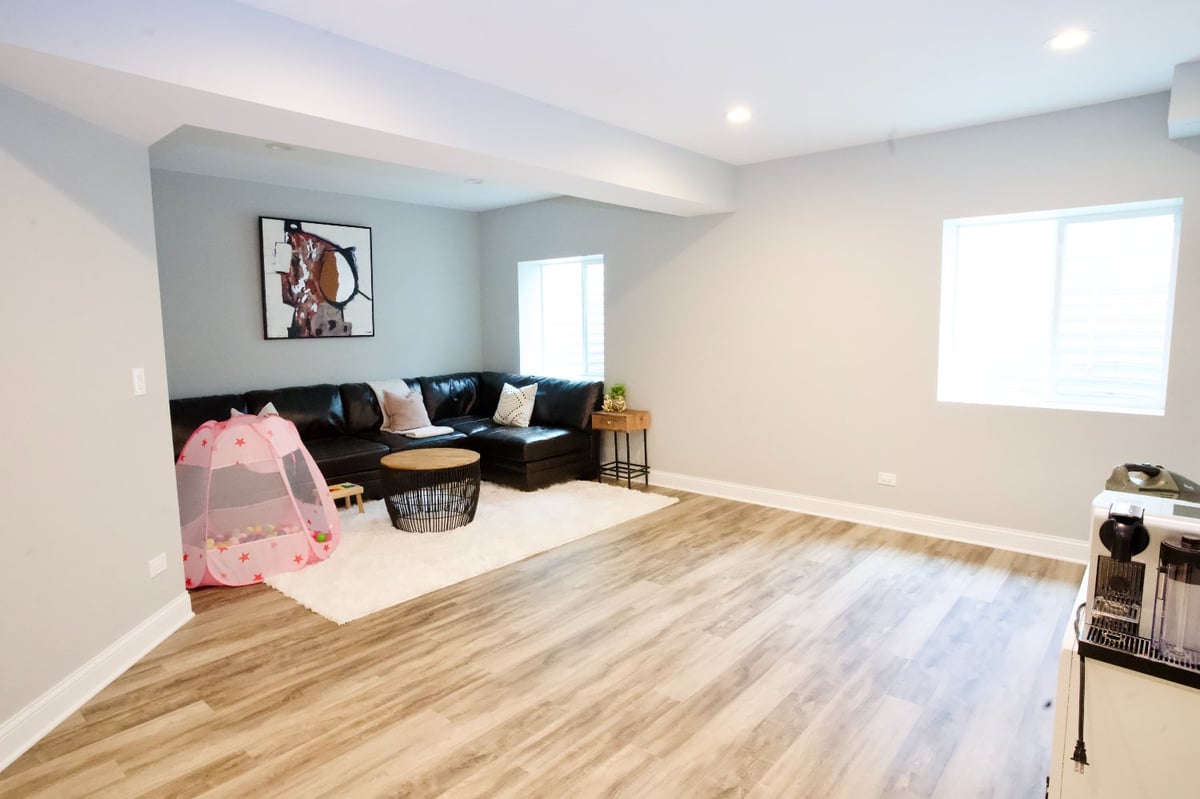 spacious basement family room remodel by Skor Construction in Hoffman Estates, IL featuring luxury flooring and comfortable gath-optimized