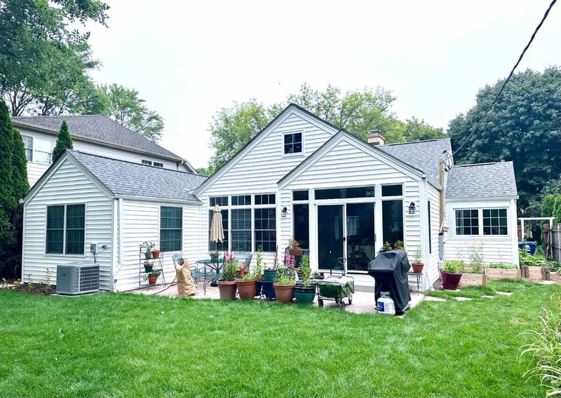 backyard view showcasing the existing patio and rear elevation prior to a sunroom addition project by Skor Construction in Wilme-optimized