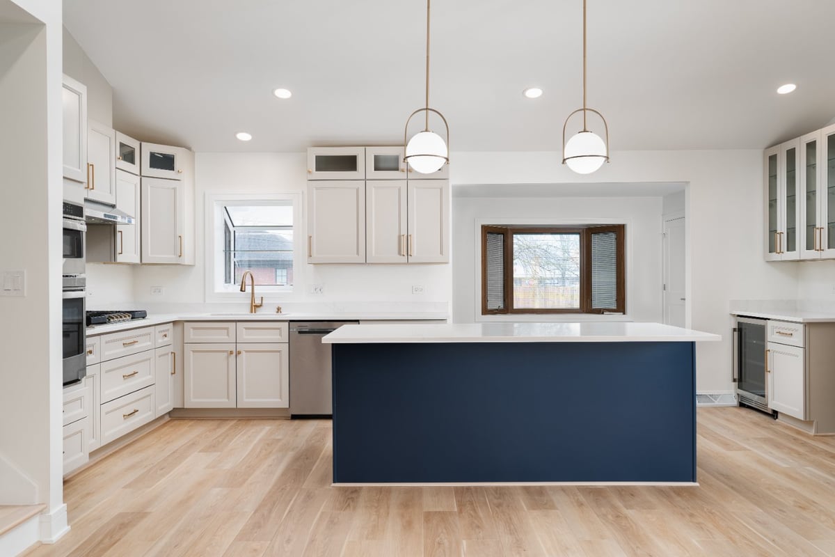 Skor Construction kitchen remodel in Arlington Heights, IL featuring a navy blue island, custom white cabinetry, and brass penda-optimized