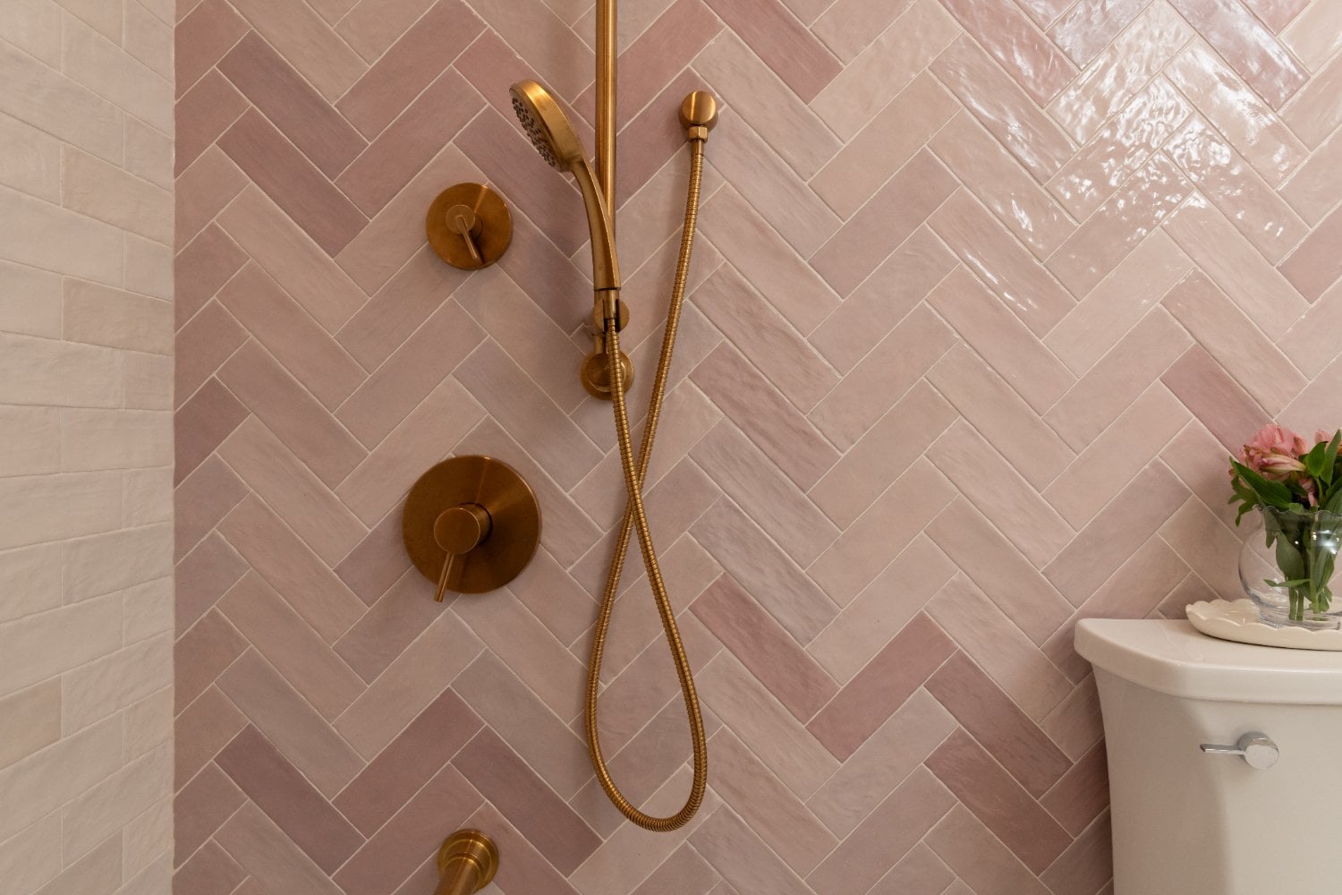 luxury blush bathroom in Mount Prospect, IL by Skor Construction featuring blush tile and modern gold plumbing hardware.