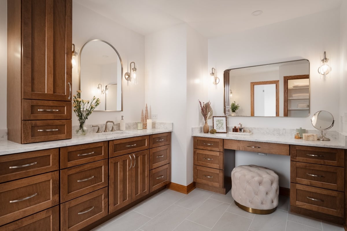 Wide view of a remodeled primary bathroom in Inverness, IL by Skor Construction featuring a makeup vanity and double sinks.-optimized