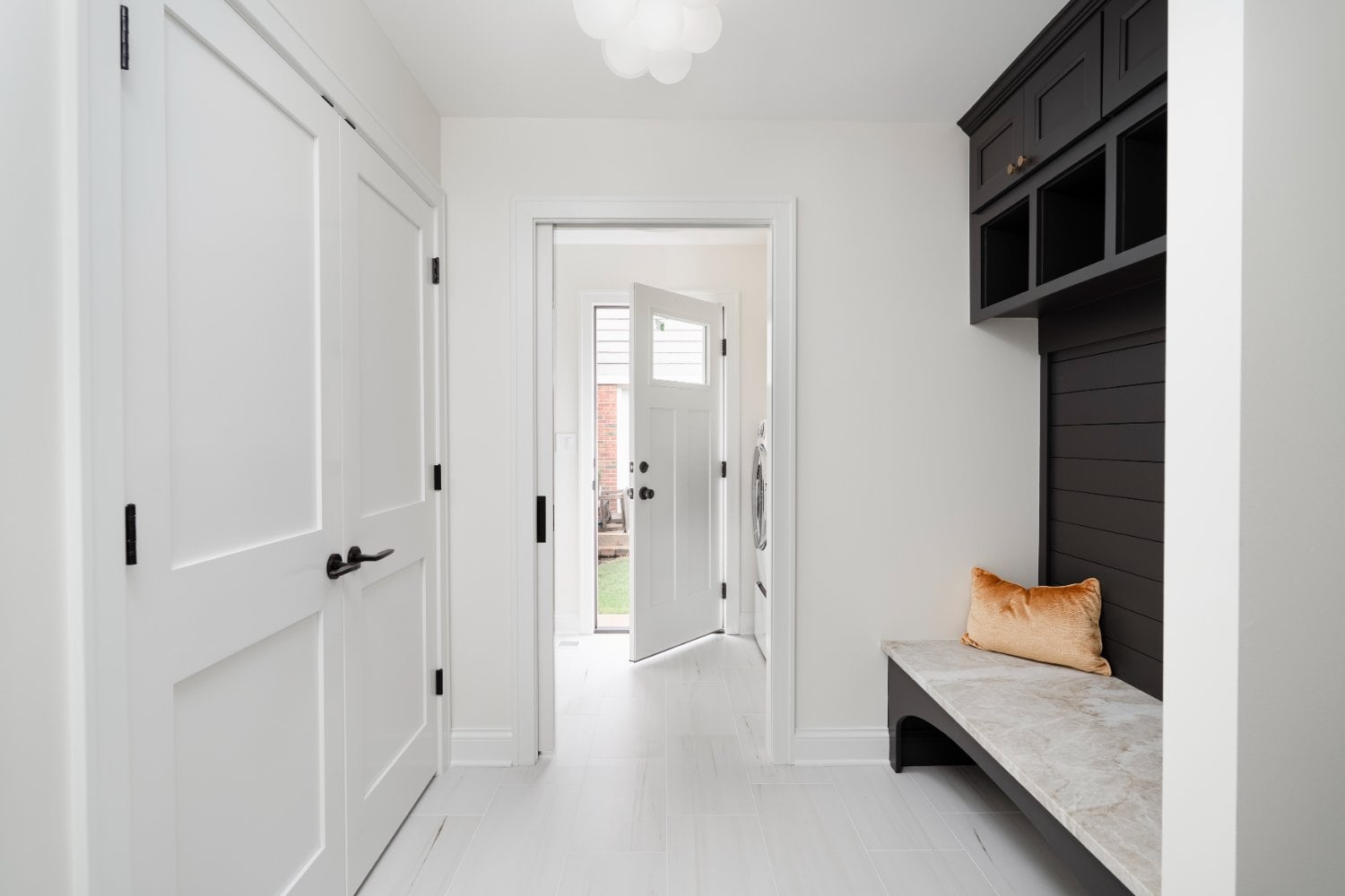 Functional mudroom remodel by Skor Construction in Mount Prospect, IL featuring custom cabinetry, stone bench seating, and open -optimized