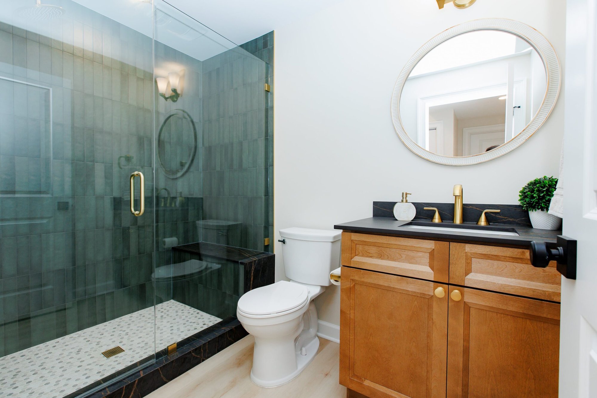 Dark green tile shower with brown and black vanity in basement bathroom remodel in North Barrington by Skor Construction Dark green tile shower with brown and black vanity in basement bathroom remodel in North Barrington by Skor Construction