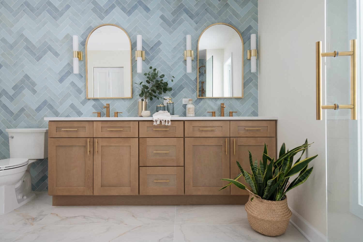 Lama primary bathroom vanity by Skor Construction in Mount Prospect, IL with blue herringbone tile and natural wood cabinetry.-optimized