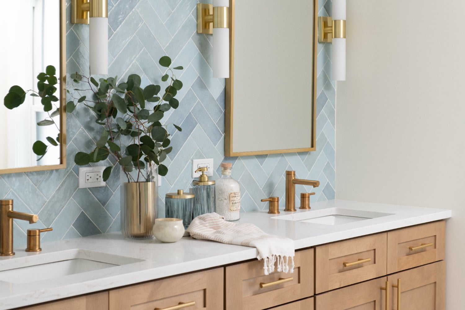 detailed view of the Lama primary bathroom vanity by Skor Construction in Mount Prospect, IL with dual sinks and gold hardware.-optimized