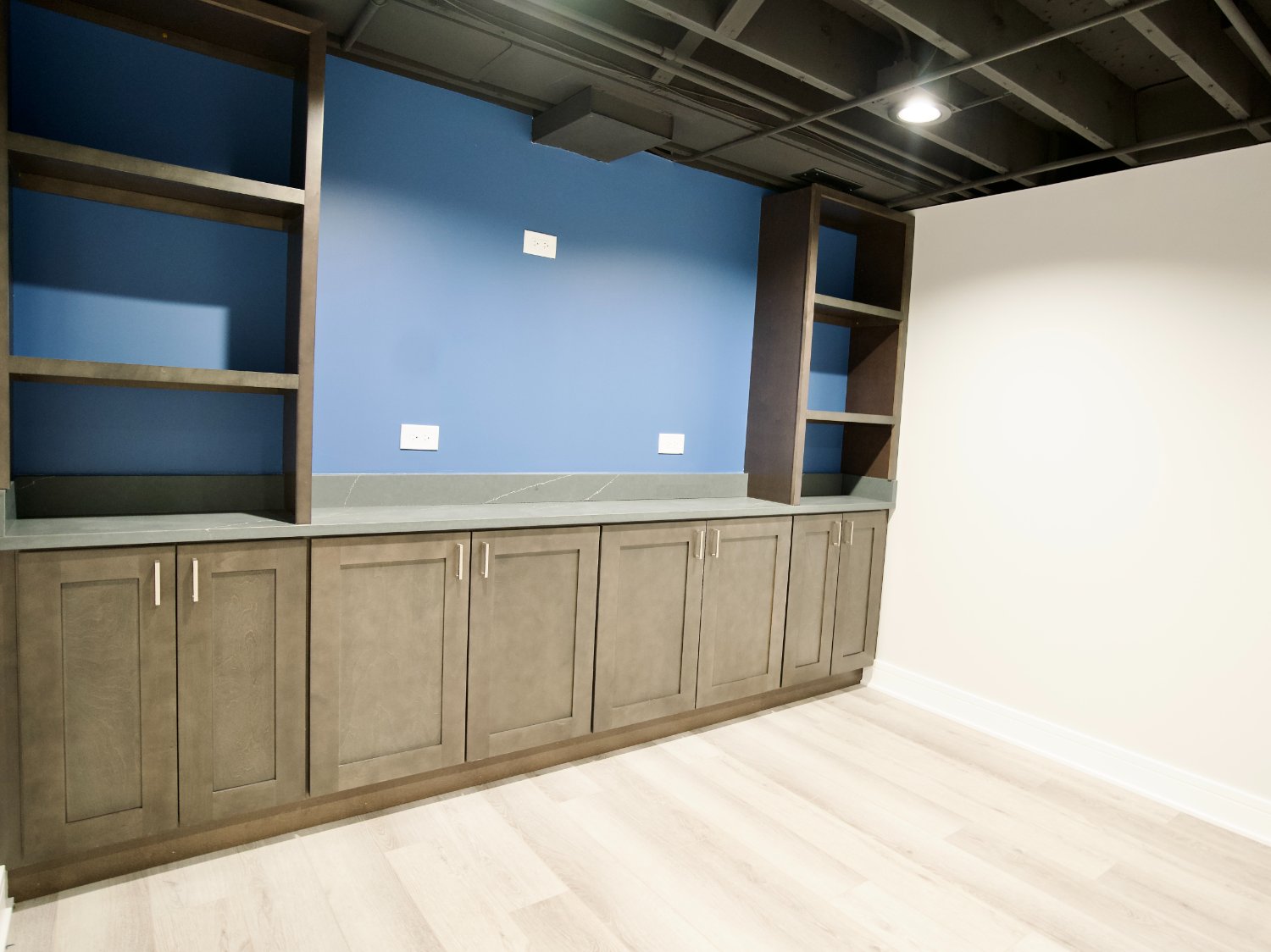modern basement remodel in Riverwoods, IL by Skor Construction featuring custom built-ins and luxury vinyl flooring.-optimized
