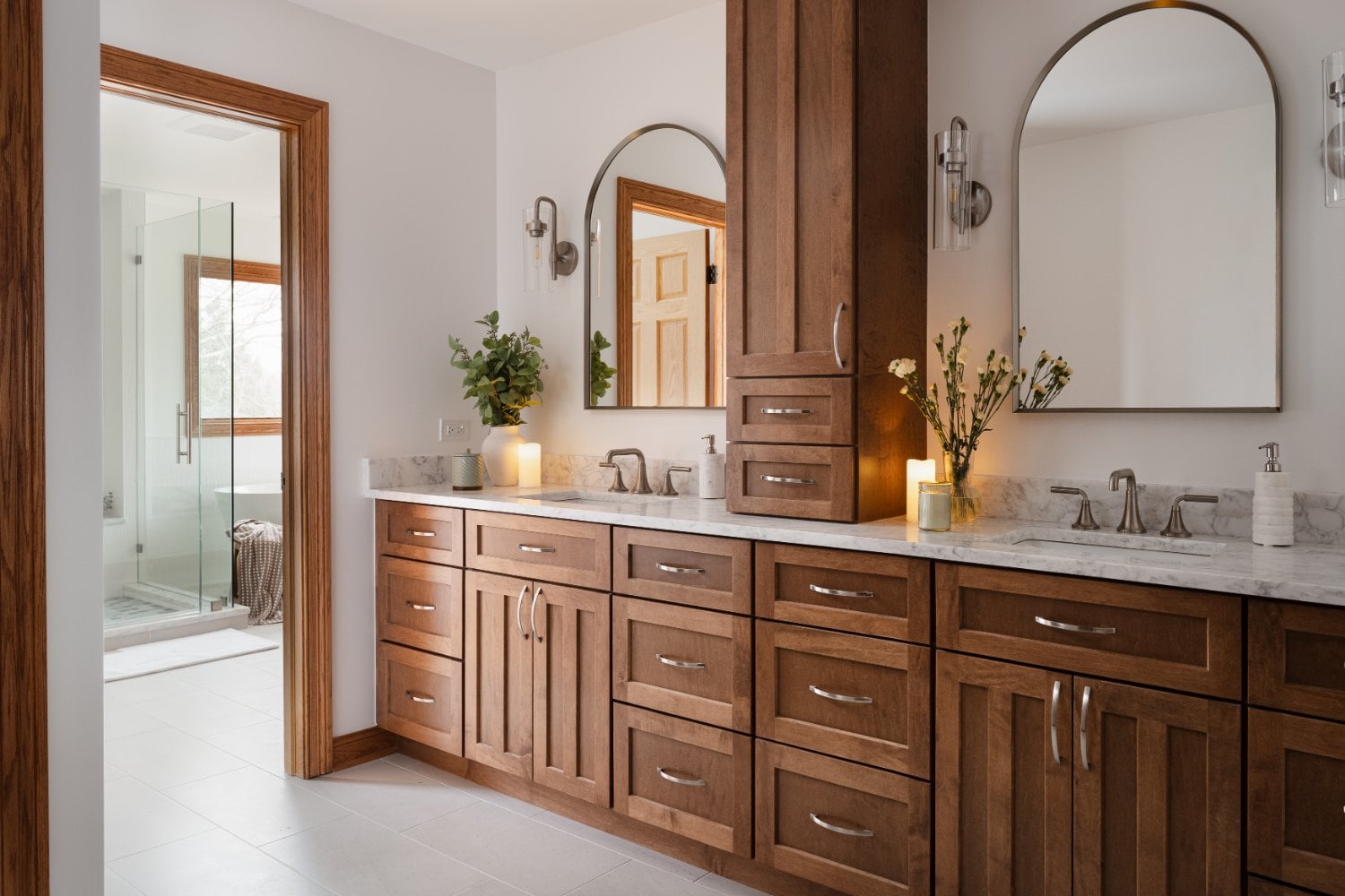Angled view of a remodeled primary bathroom vanity in Inverness, IL by Skor Construction with arched mirrors and brushed nickel -optimized