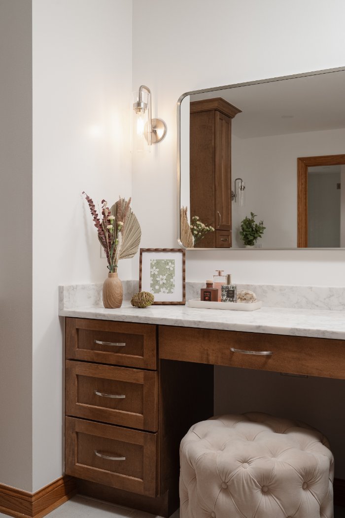 Close-up of a remodeled bathroom vanity area in Inverness, IL by Skor Construction with decorative accents and tufted seating.-optimized