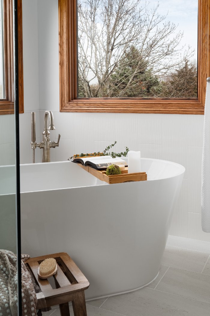 Elegant freestanding bathtub from a Skor Construction primary bathroom remodel in Inverness, IL with modern fixtures and wood tr-optimized