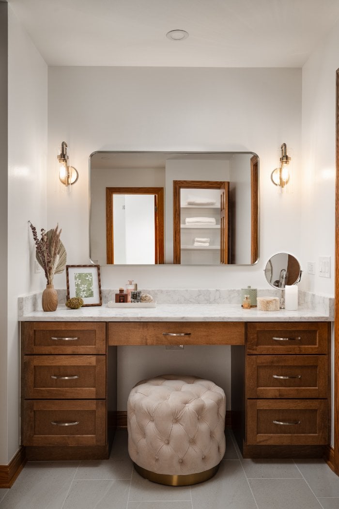 Elegant vanity nook from a Skor Construction primary bathroom remodel in Inverness, IL with modern sconces and marble surfaces.-optimized