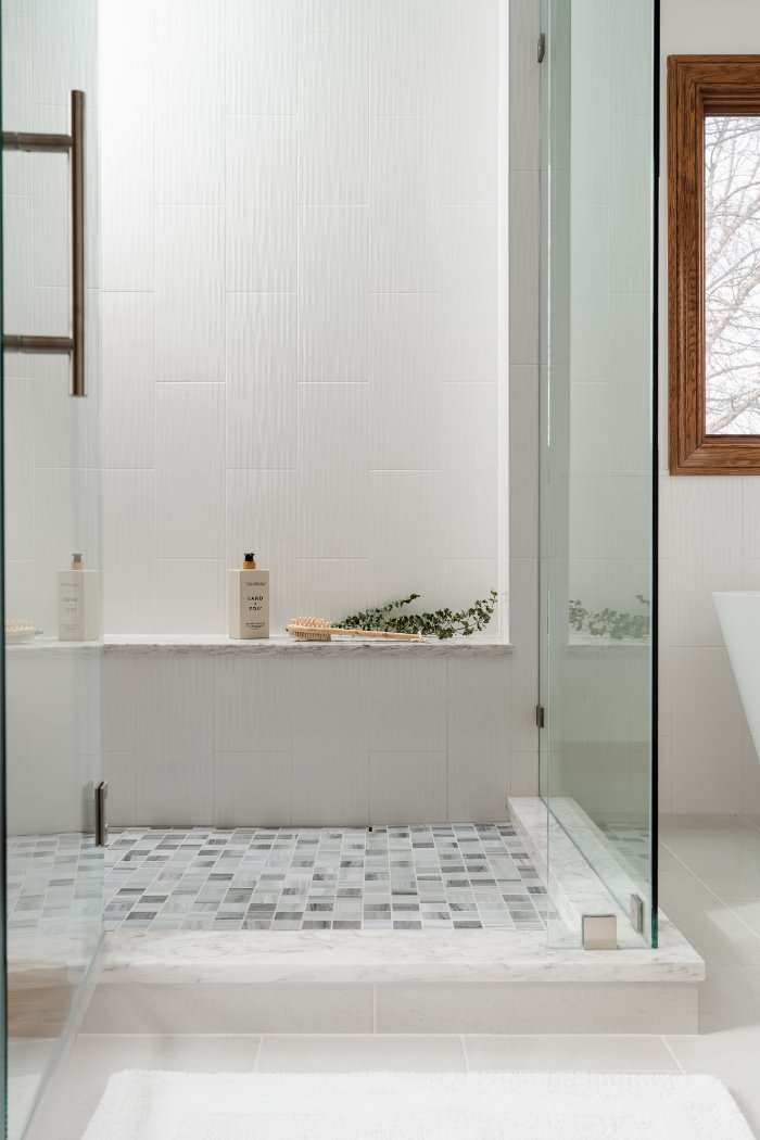 Skor Construction Lauder Primary Bathroom Remodel in Inverness, IL with frameless glass shower and textured white wall tile.-optimized