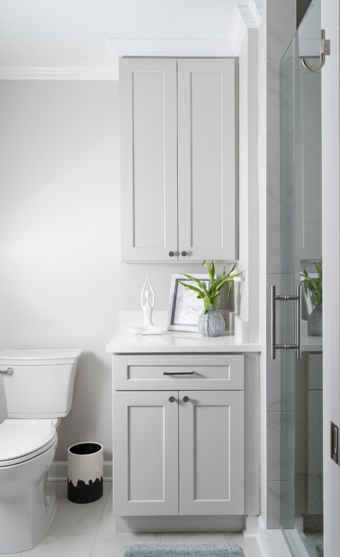 Bright primary bathroom design in Lincolnshire, IL with white shaker cabinetry, quartz countertops, and modern shower enclosure.-optimized