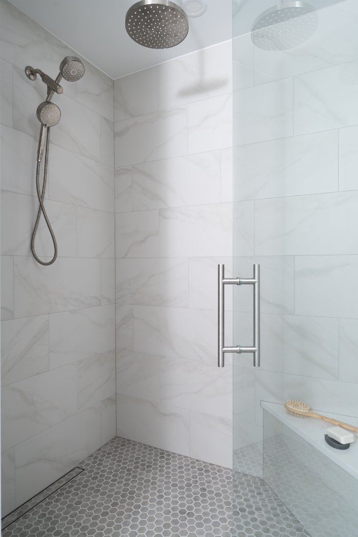 Modern walk-in shower in Lincolnshire, IL with brushed nickel fixtures, hexagon tile flooring, and clean contemporary design.-optimized