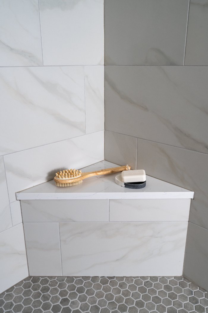 Skor Construction Mayland Villa bathroom remodel in Lincolnshire, IL featuring a built-in shower bench with marble-look tile sur-optimized
