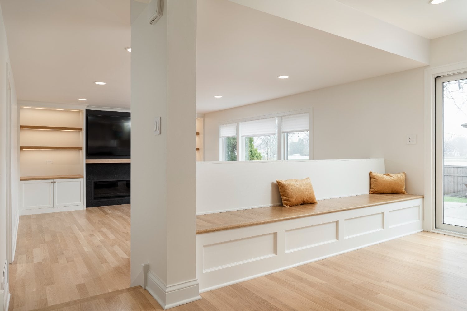 Bright living space remodel by Skor Construction in Mount Prospect, IL with built-in bench seating, hardwood flooring, and reces-optimized