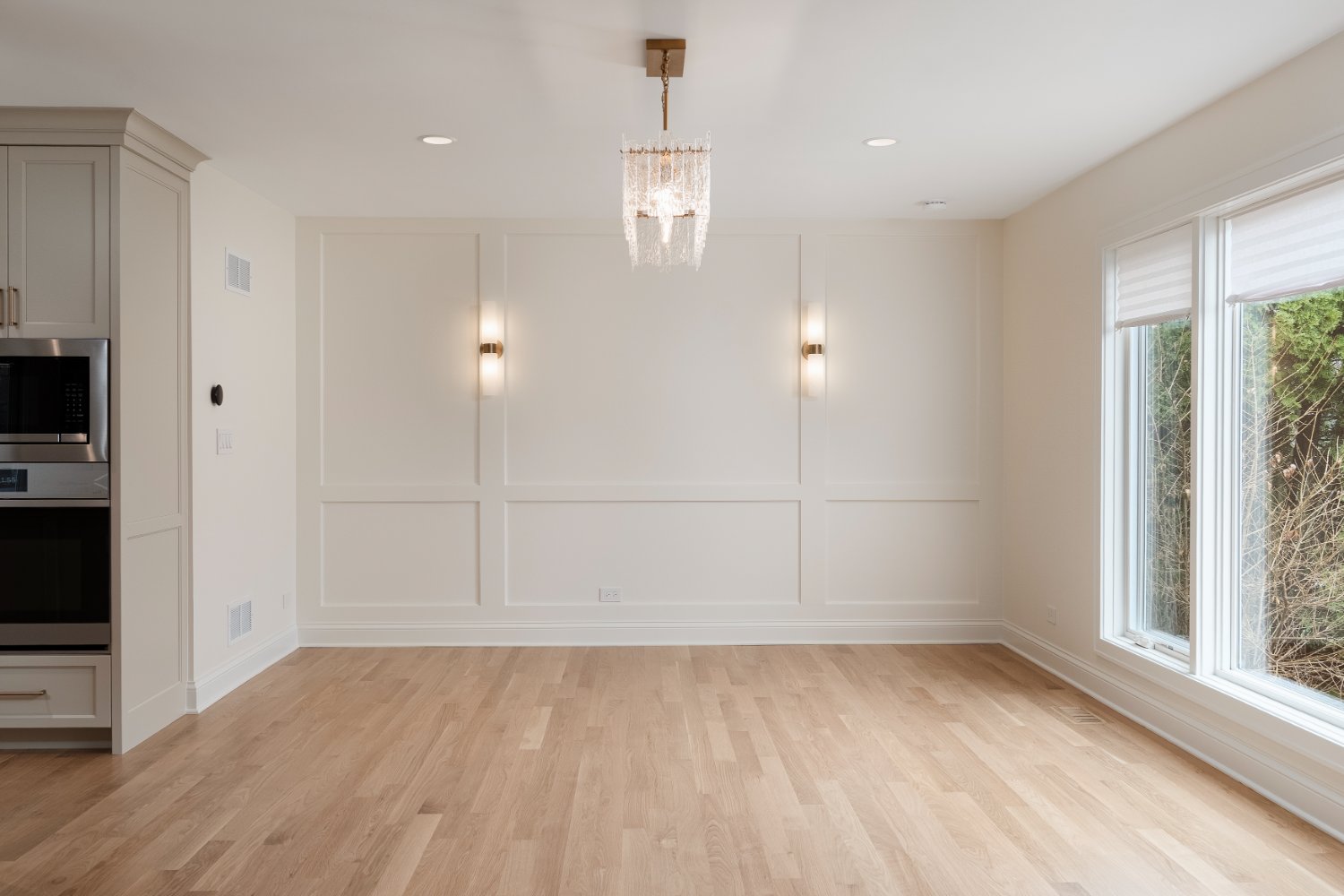 Elegant open-concept dining area remodel by Skor Construction in Mount Prospect, IL with large windows, wall sconces, and contem-optimized