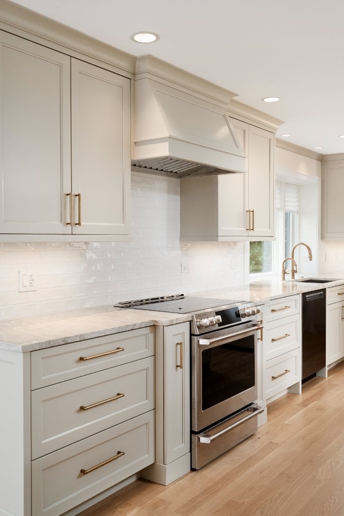 Luxury kitchen renovation by Skor Construction in Mount Prospect, IL featuring a custom hood vent, subway tile backsplash, and b-optimized