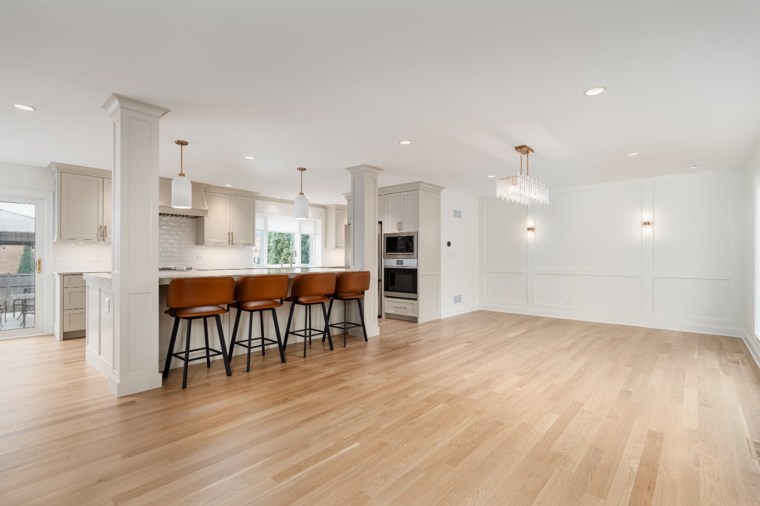 Luxury main level remodel by Skor Construction in Mount Prospect, IL with custom white cabinetry, modern lighting, and open dini-optimized