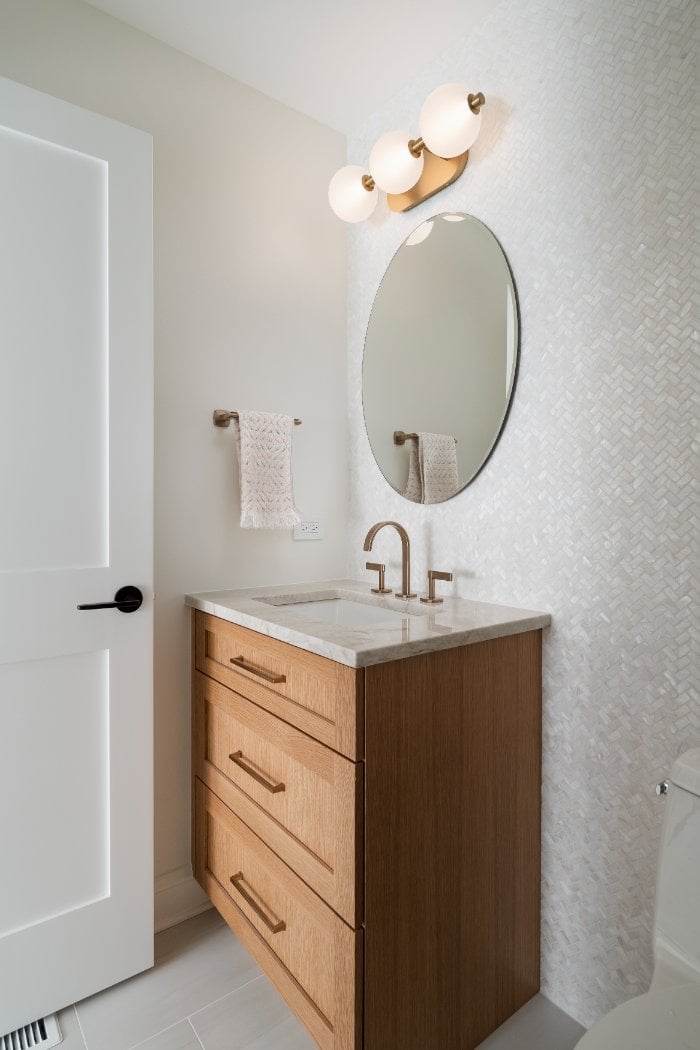 Skor Construction bathroom renovation in Mount Prospect, IL featuring a custom wood vanity, marble countertop, and textured tile-optimized