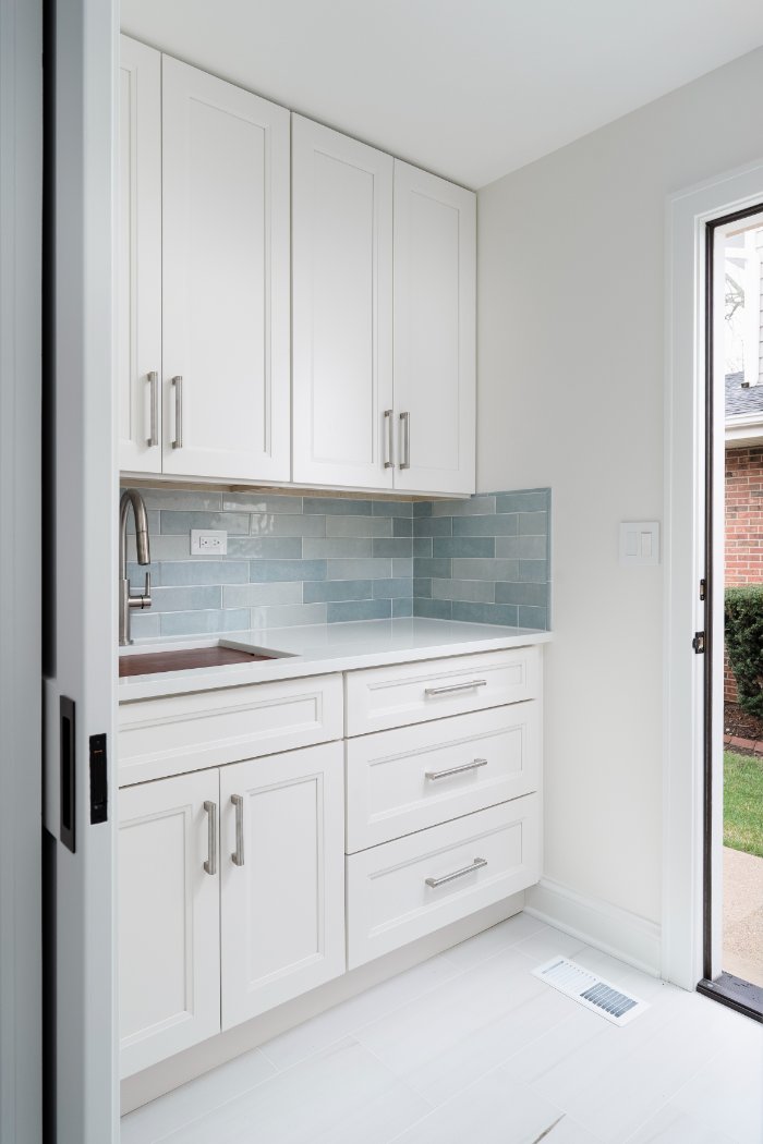 Skor Construction laundry room remodel in Mount Prospect, IL featuring white shaker cabinetry, blue subway tile backsplash, and -optimized
