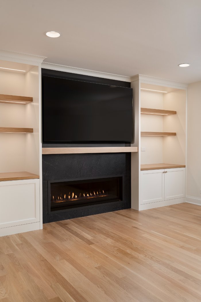 Skor Construction living room renovation in Mount Prospect, IL featuring custom built-in shelving, modern fireplace surround, an-optimized