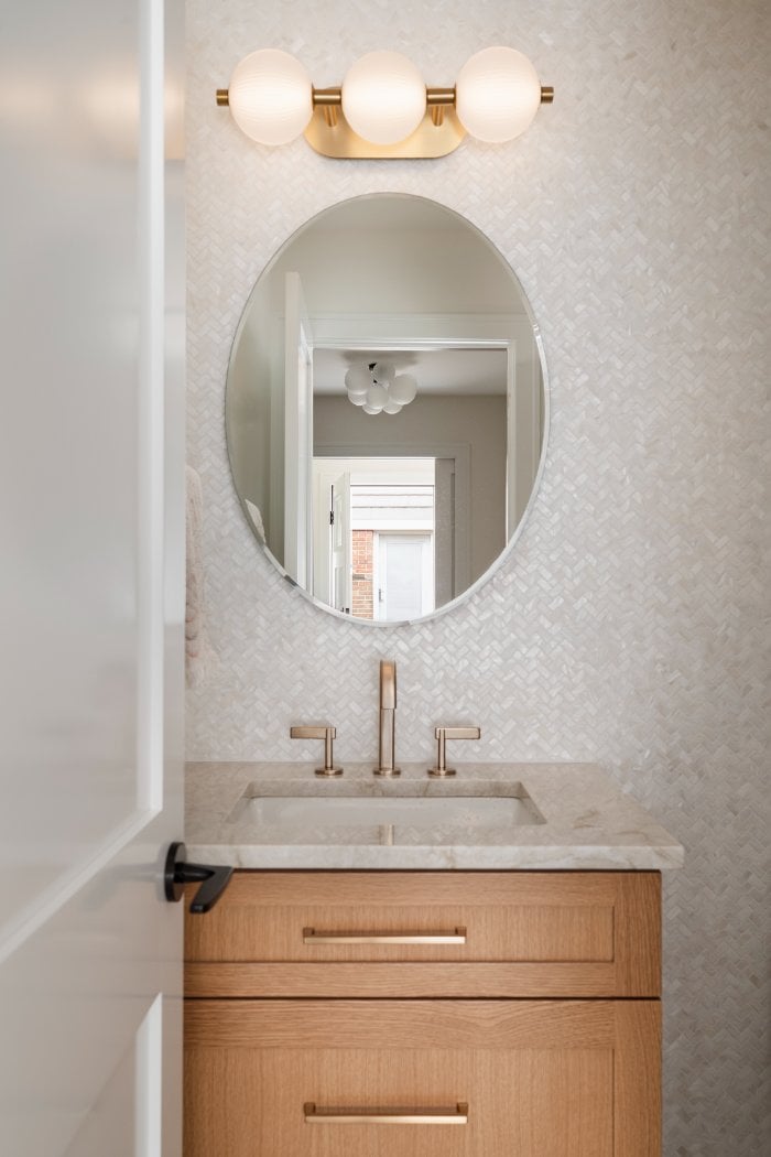 Skor Construction powder room renovation in Mount Prospect, IL featuring a floating wood vanity, brass fixtures, and textured wh-optimized Skor Construction powder room renovation in Mount Prospect, IL featuring a floating wood vanity, brass fixtures, and textured wh-optimized